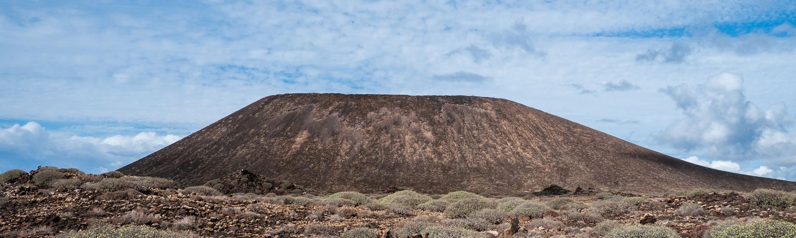 La Caldera de Lobos, el cono volcánico más alto de la isla, entre el malpaís