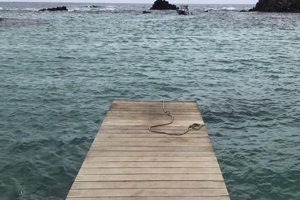 Pantalán de madera en El Puertito de Lobos sobre agua transparente