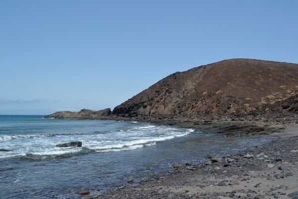 Costa rocosa de la Isla de Lobos con el cono volcánico al fondo